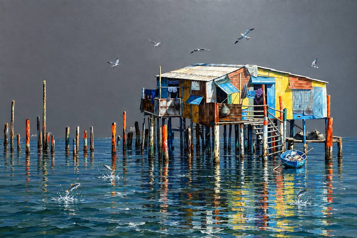 Colourful stilt house on wooden poles over turquoise water with seagulls and a grey sky